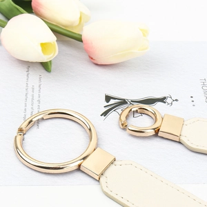 Elastic black waist belt for women with elegant golden metal ring and cream leather detail
