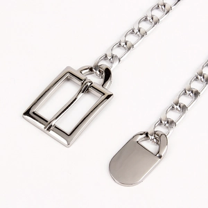 Macro view of silver chunky Cuban chain belt with polished metal tag and pin buckle