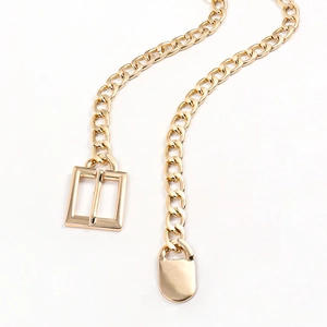 Detail of a shiny gold chain belt with polished metal rings and a sleek rectangle buckle