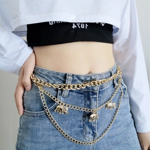 Detail of gold multi-layered waist chain featuring elephant charms on blue jeans