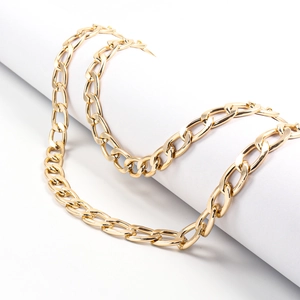 Close-up of chunky gold waist chain with polished links wrapped on a white display pillar