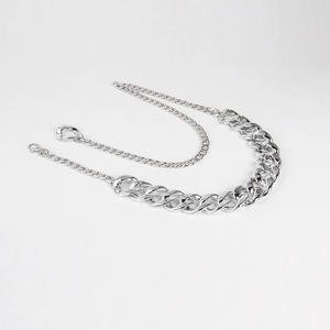Close-up of thick silver chunky metal chain belt with lobster clasp and round buckle