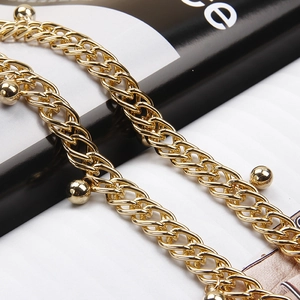 Chaîne de taille dorée à double couche tressée avec pendentifs perlés sur magazine