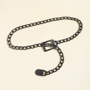 Detailed close-up of gunmetal thick chain belt with rectangular eyelet and oval pendant