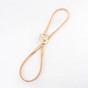 Detail view of gold-tone elastic metal belt featuring a double-ring interlaced buckle