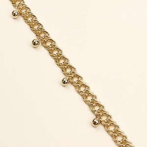 Détail d'une chaîne dorée à double boucle avec des perles polies et un design en spirale