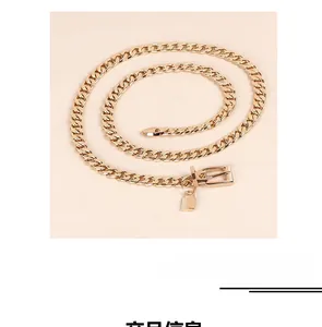 Detail of chunky gold metal waist chain featuring a polished padlock pendant and buckle
