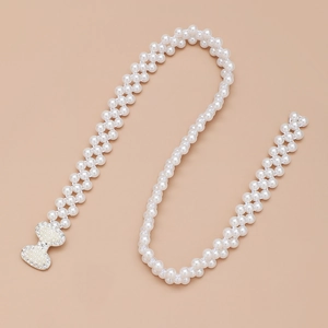 Dettaglio catena in perle per vita con fibbia a fiocco in strass per abiti eleganti