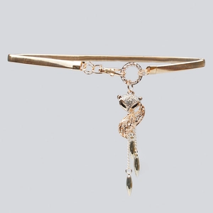 Detail of golden elastic waist belt featuring a crystal fox pendant and chain tassels