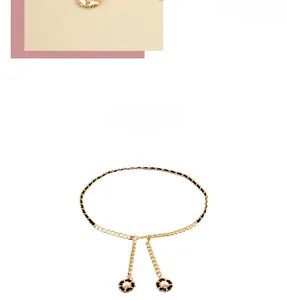 Detail of woven gold chain waist belt with camellia pendants and pearl accents