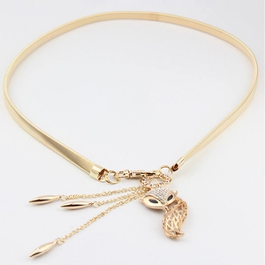 Close-up of golden metal waist chain featuring a fox pendant and delicate tassels