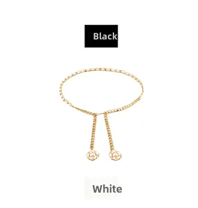 Close-up of golden metal waist chain with camellia pendants and pearl accents