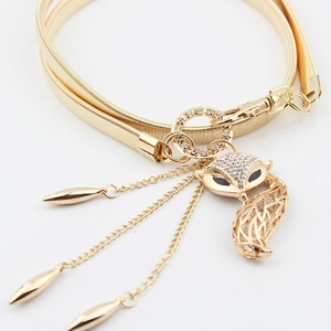 Detail of fox-shaped pendant with crystals and tassels on gold elastic metal waist belt