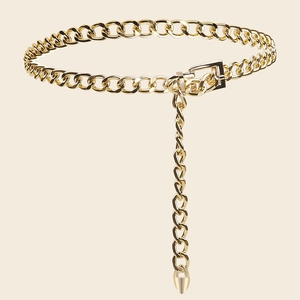 Detailed close-up of golden metal chain belt with square buckle and conical charm