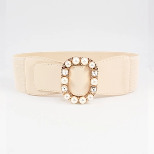 Detail of elastic waist belt featuring luxury pearls and rhinestones on beige leather
