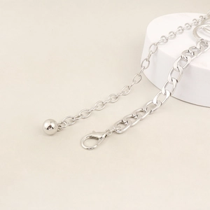 Close-up of silver multilayer chain belt with lobster clasp and round ball pendant