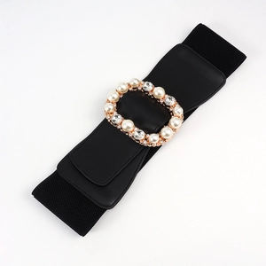 Close-up of black elastic waist belt with luxury rhinestone and pearl buckle detail