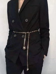 Detail of a gold braided waist chain with pearl floral pendants on a black blazer jacket