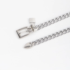 Close-up of a silver Cuban link chain belt featuring a square pin buckle and padlock charm