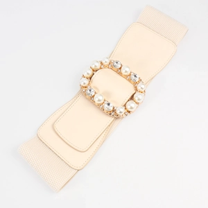 Detail of cream elastic waist belt featuring a gold buckle with pearls and rhinestones