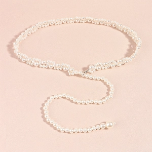 Detailed close-up of woven pearl waist chain belt with silver lobster clasp and pearl pendant