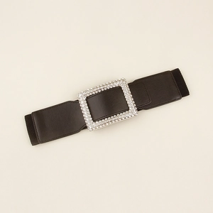 Detail of high-elastic black waist belt with a large sparkling rhinestone buckle