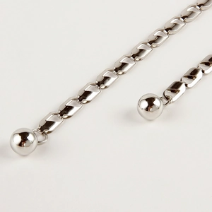 Détail d'une chaîne de taille en métal argenté avec pendentifs boules pour robes