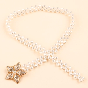 Close-up of woven pearl waist chain with a sparkling gold star buckle and rhinestones