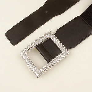Detail of wide elastic waist belt featuring a large rectangular rhinestone buckle for coats