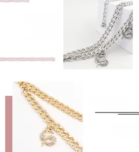 Detail of double-layered gold waist chain with a sparkling dragon pendant and cuban links