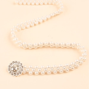 Detail of elegant double-row pearl waist chain with sparkling floral rhinestone buckle
