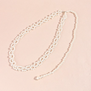 Close-up of woven pearl belt featuring a hollow lattice design and large drop pearl detail