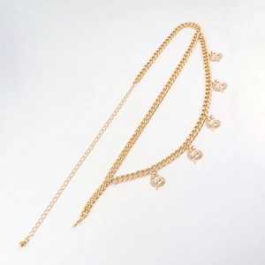 Detail of gold-layered waist chain featuring sparkling rhinestone dragon pendants