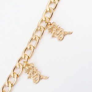 Detail shot of a double-layered gold chain belt featuring intricate Chinese dragon pendants
