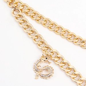 Close-up of golden Cuban link chain featuring a dragon pendant with sparkling rhinestones