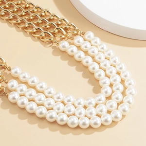 Detailed close-up of triple-layer pearl and gold chain waist belt for dresses