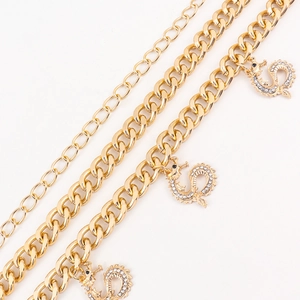 Detail of double-layer gold waist chain with intricate dragon pendants and rhinestones