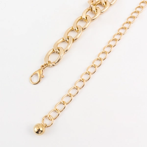 Detail view of gold metal waist chain with adjustable extender and lobster clasp