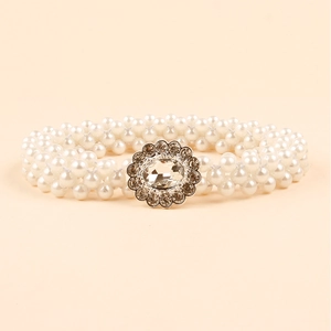 Detail of elegant multi-row pearl waist belt with silver floral diamond buckle decoration