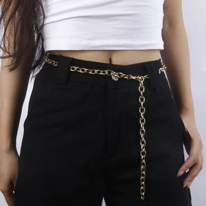 Vue détaillée d'une ceinture chaîne dorée avec maillons ovales polis portée sur un pantalon