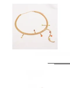 Détail d'une chaîne de taille argentée à double couche avec des pendentifs de fruits colorés