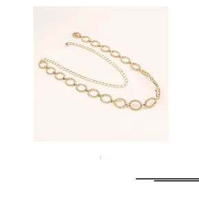 Close-up of golden hollow oval links and double-layered metal chain belt detail