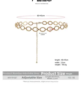 Detail view of golden metal waist chain featuring textured oval links and adjustable lobster clasp