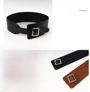 Détail de la boucle carrée argentée sur les ceintures larges en similicuir noir et marron