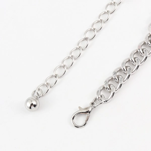 Detailed macro view of silver cuban chain with lobster clasp and metal ball pendant