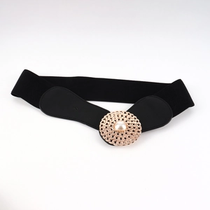 Détail d'une large ceinture élastique noire avec boucle dorée ornée d'une perle nacrée