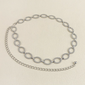 Detailed view of silver metallic waist chain with hollow oval twist links and lobster clasp