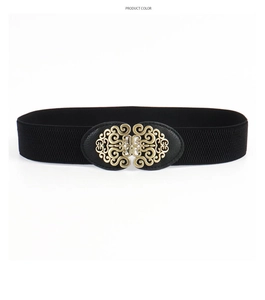 Detail of vintage gold hollowed-out scroll pattern buckle on a black elastic belt