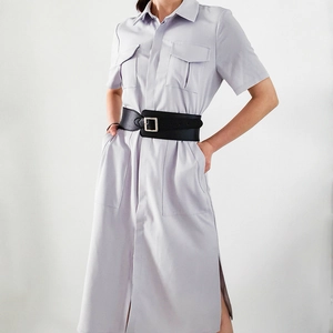 Détail d'une large ceinture noire portée sur une robe chemise à manches courtes lavande