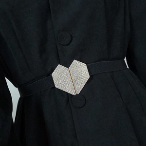Détail d'une ceinture élastique noire pour femme avec boucle en forme de cœur à strass